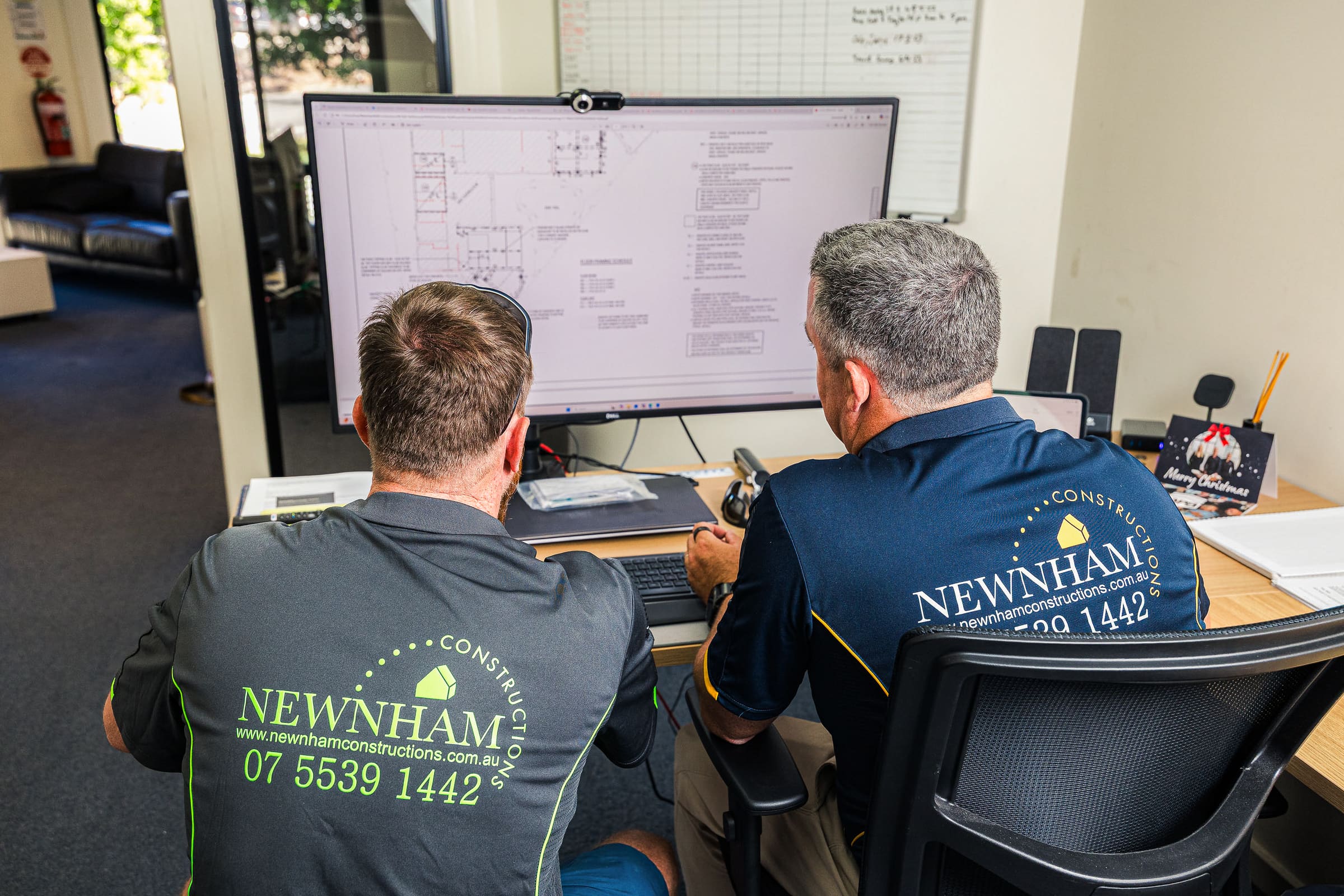 Newnham Constructions team reviewing construction drawings on screen